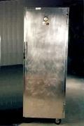 A large stainless steel refrigerator is sitting in a dark room.