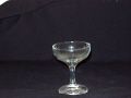 A small wine glass is sitting on a black table.