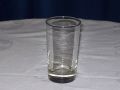 A clear glass is sitting on top of a white table cloth.