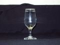 A wine glass is sitting on a black table cloth.