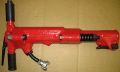 A red air hammer is sitting on top of a cardboard box.