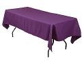 A long table with a purple tablecloth on it.