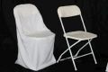 Two white folding chairs with white covers are sitting next to each other on a black background.