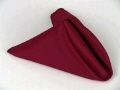 A red napkin folded into a triangle on a white surface.