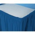 A blue table skirt with a white table cloth on top of it.