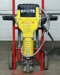 A yellow bosch demolition hammer is sitting on top of a red cart.
