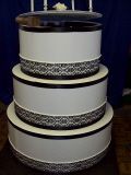 A three tiered cake is sitting on top of a wooden table.