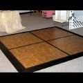 A wooden dance floor with a black frame in a room.