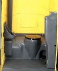 A portable toilet is sitting inside of a yellow box.