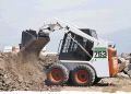 A bobcat is digging in the dirt on a construction site.