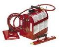 A red welding machine with a hose attached to it on a white background.