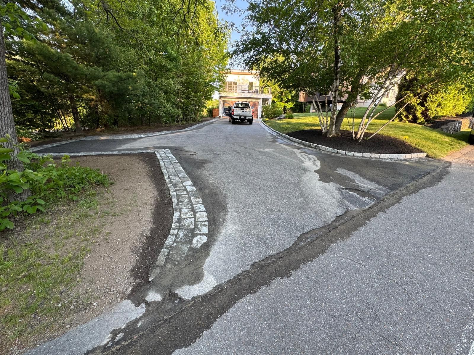 Curved paved path through a leafy park, leading toward a distant building at the center.