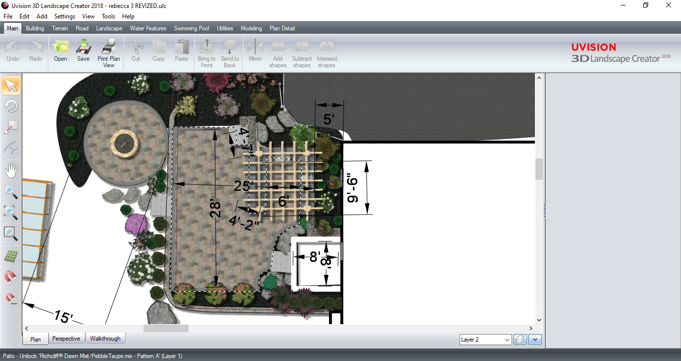 A computer screen shows a landscape design plan with stone patio, circular feature, and plantings.