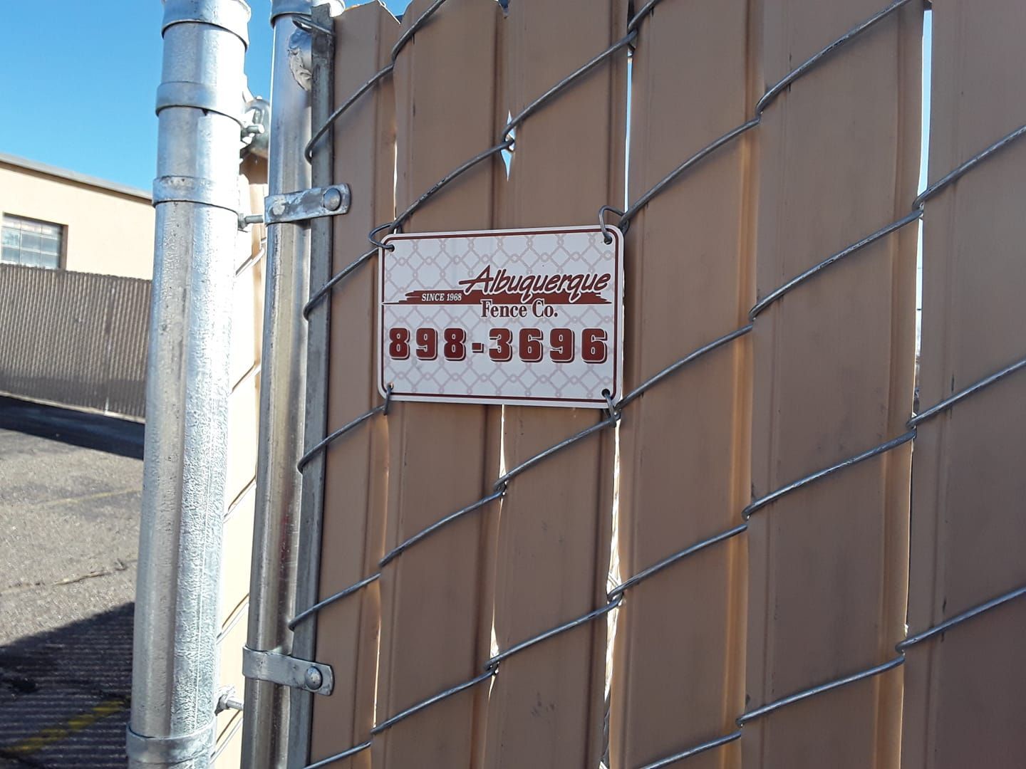 A metal gate with a sign that has a phone number 898-3696.