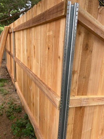 Wooden privacy fence with a metal post.
