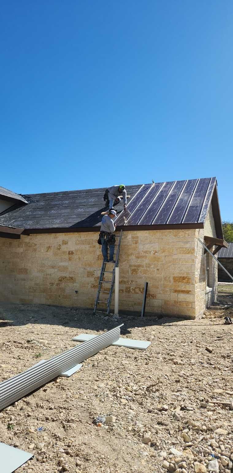 A man is standing on a ladder on the side of a house.