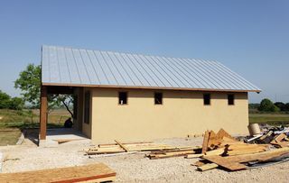 A small house with a metal roof is being built.