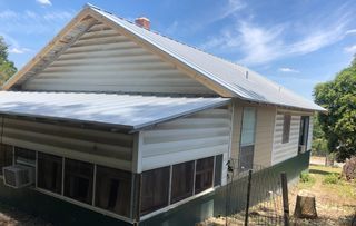 A house with a screened in porch and a metal roof.