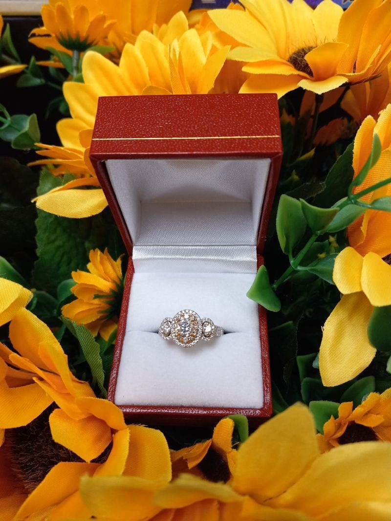 A ring in a box surrounded by yellow flowers