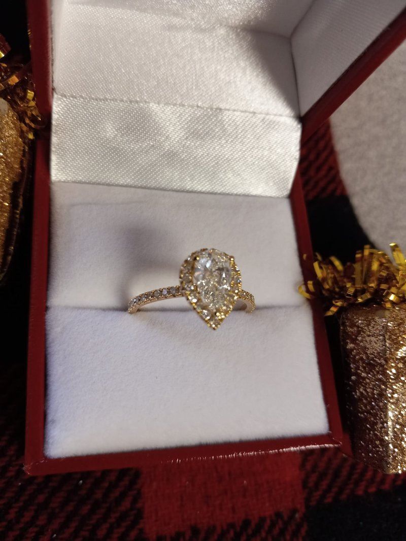 A pear shaped diamond ring in a red box