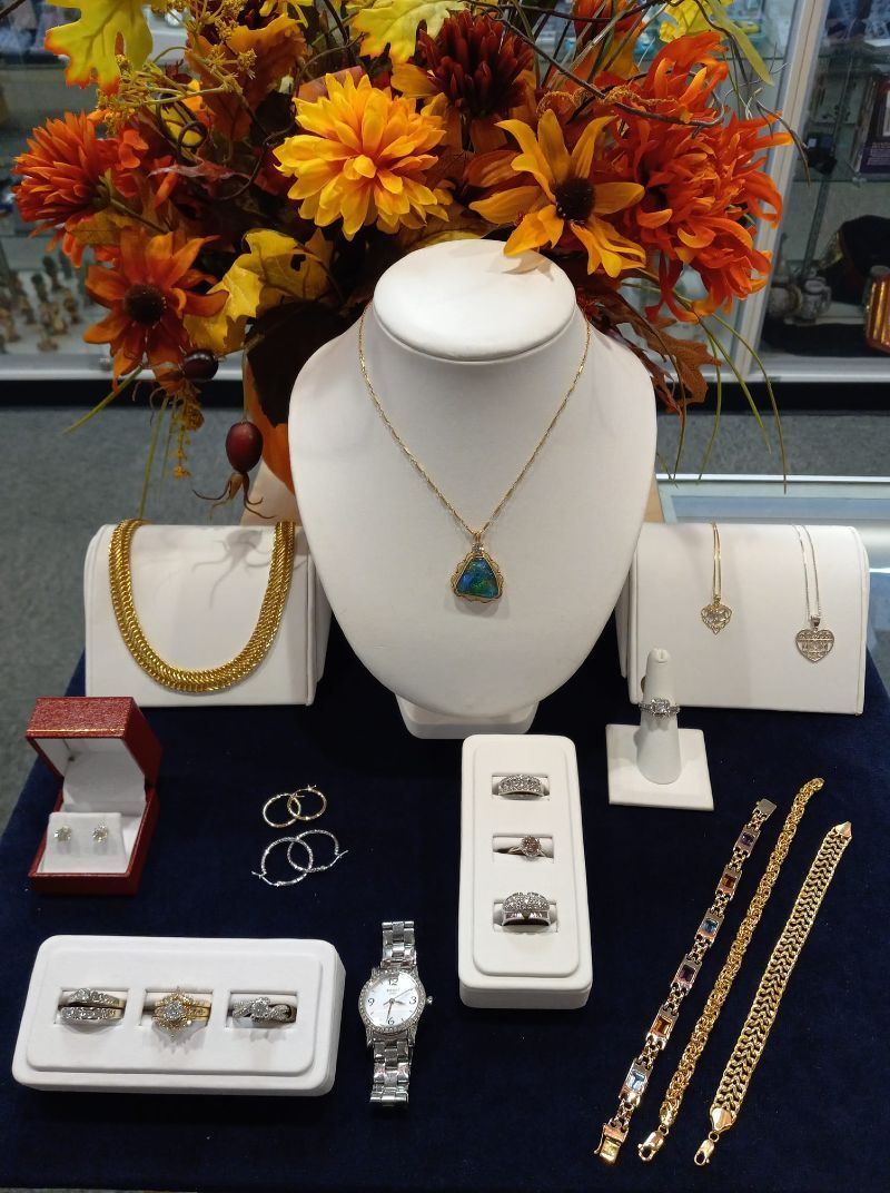 A display of jewelry with a vase of flowers in the background