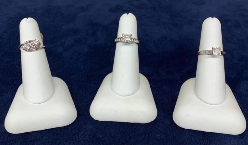 Three rings are displayed on white rings holders