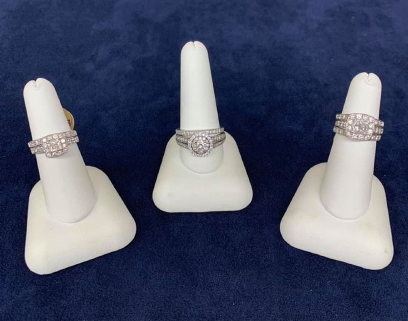 Three rings are displayed on white rings holders