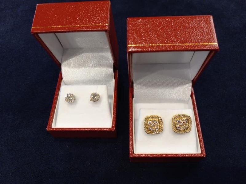 A pair of earrings and a pair of cufflinks in red boxes