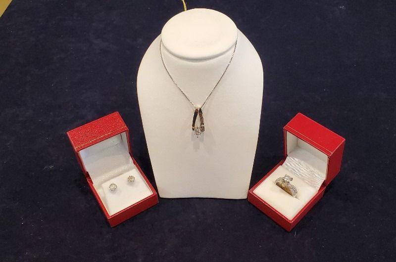 A necklace earrings and a ring are on display on a mannequin