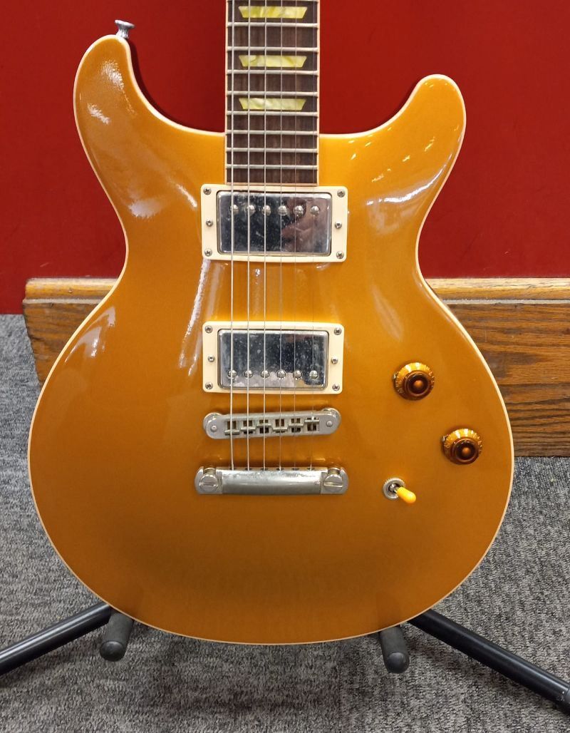 A yellow electric guitar is sitting on a stand