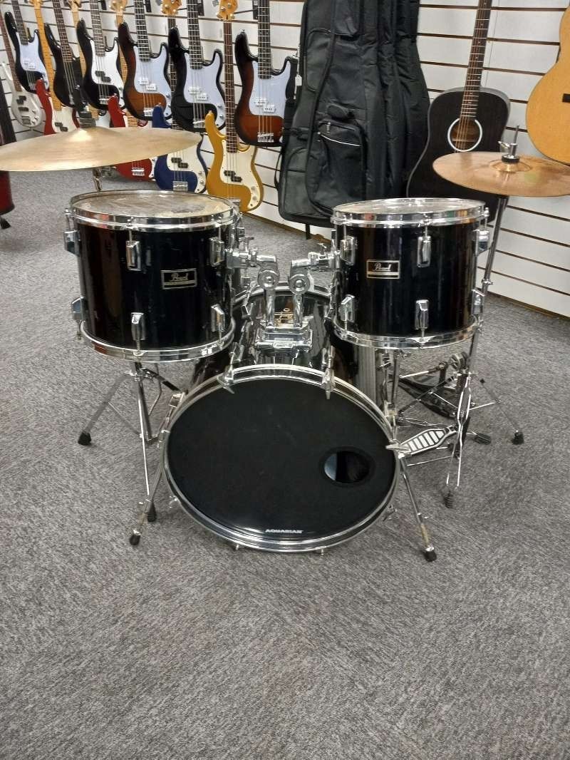 A drum set is sitting on a carpet in a store.