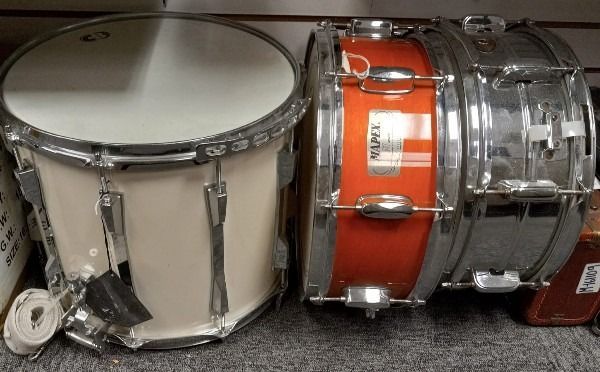 A white drum and an orange drum are next to each other