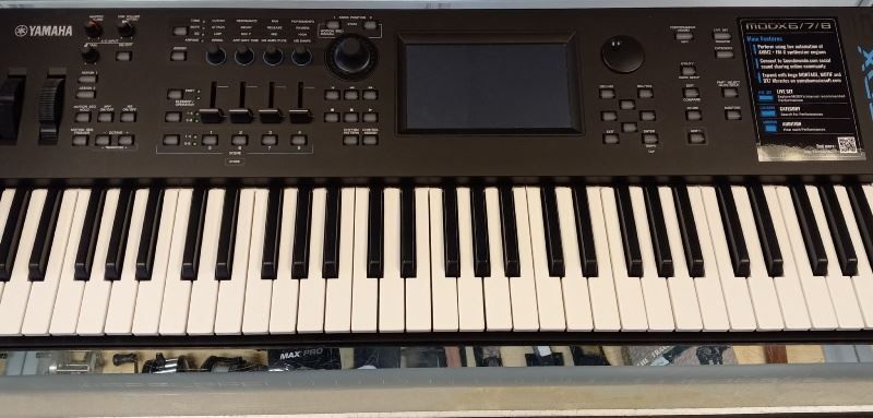 A keyboard with a screen on top of it is sitting on a table.