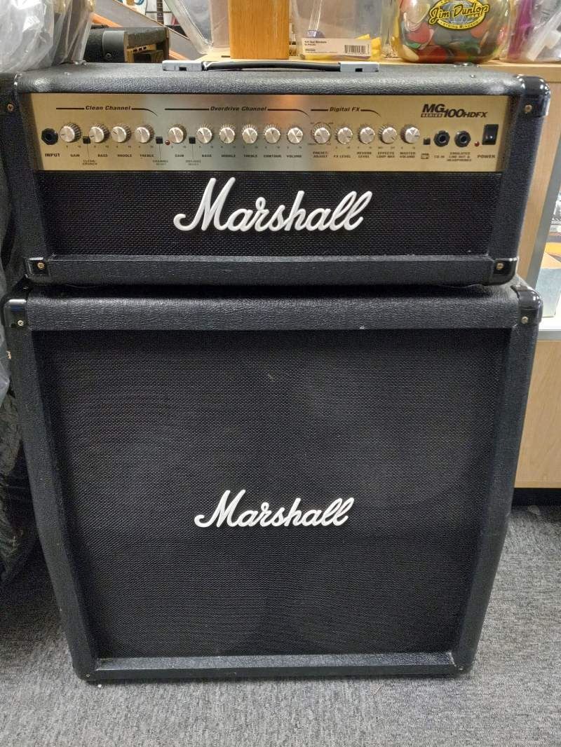 A marshall amplifier is sitting on top of a marshall speaker.