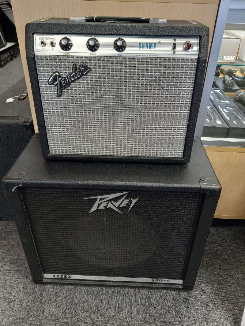 A fender amplifier is sitting on top of a black speaker.