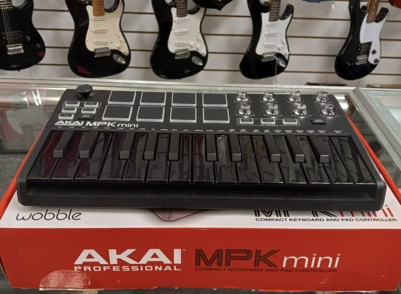 A keyboard sitting on top of a red box that says akai mpk mini