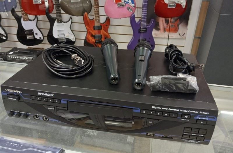 A karaoke machine with two microphones on top of it