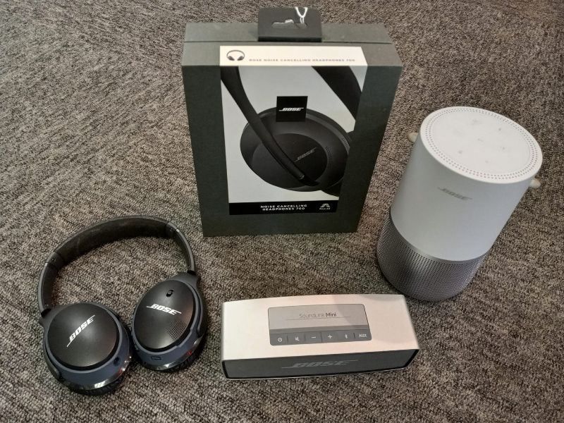 A pair of bose headphones sitting next to a speaker