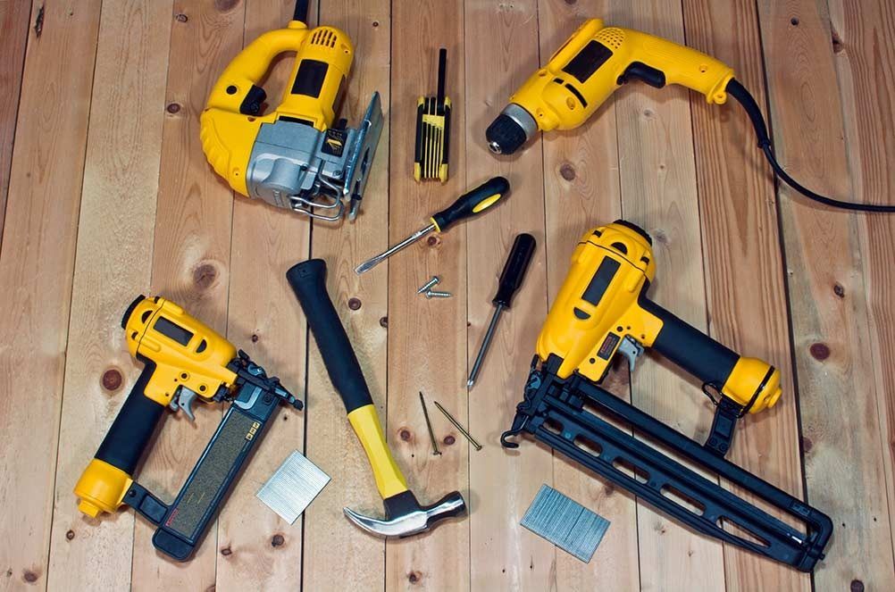 A bunch of tools are laying on a wooden floor