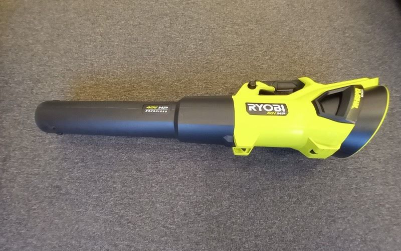 A yellow and black ryobi blower is sitting on a carpet.