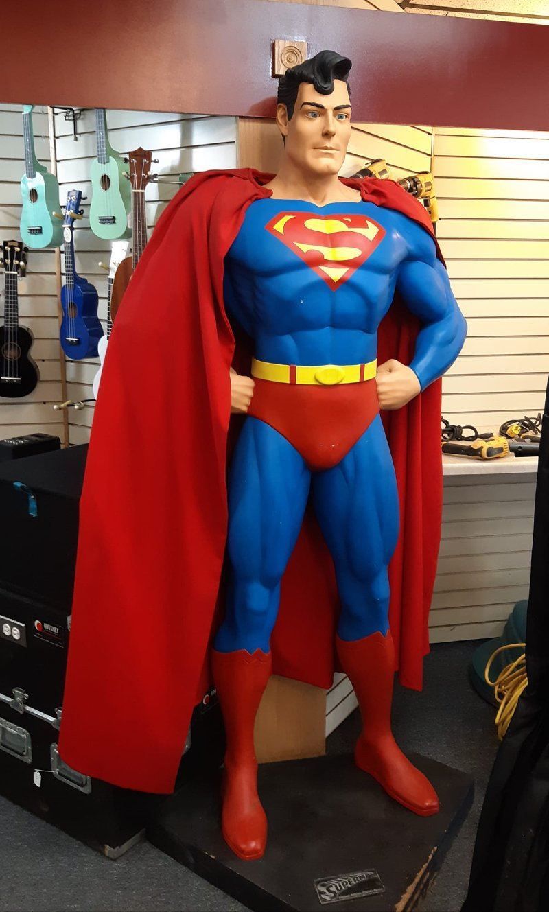 A statue of superman with a red cape