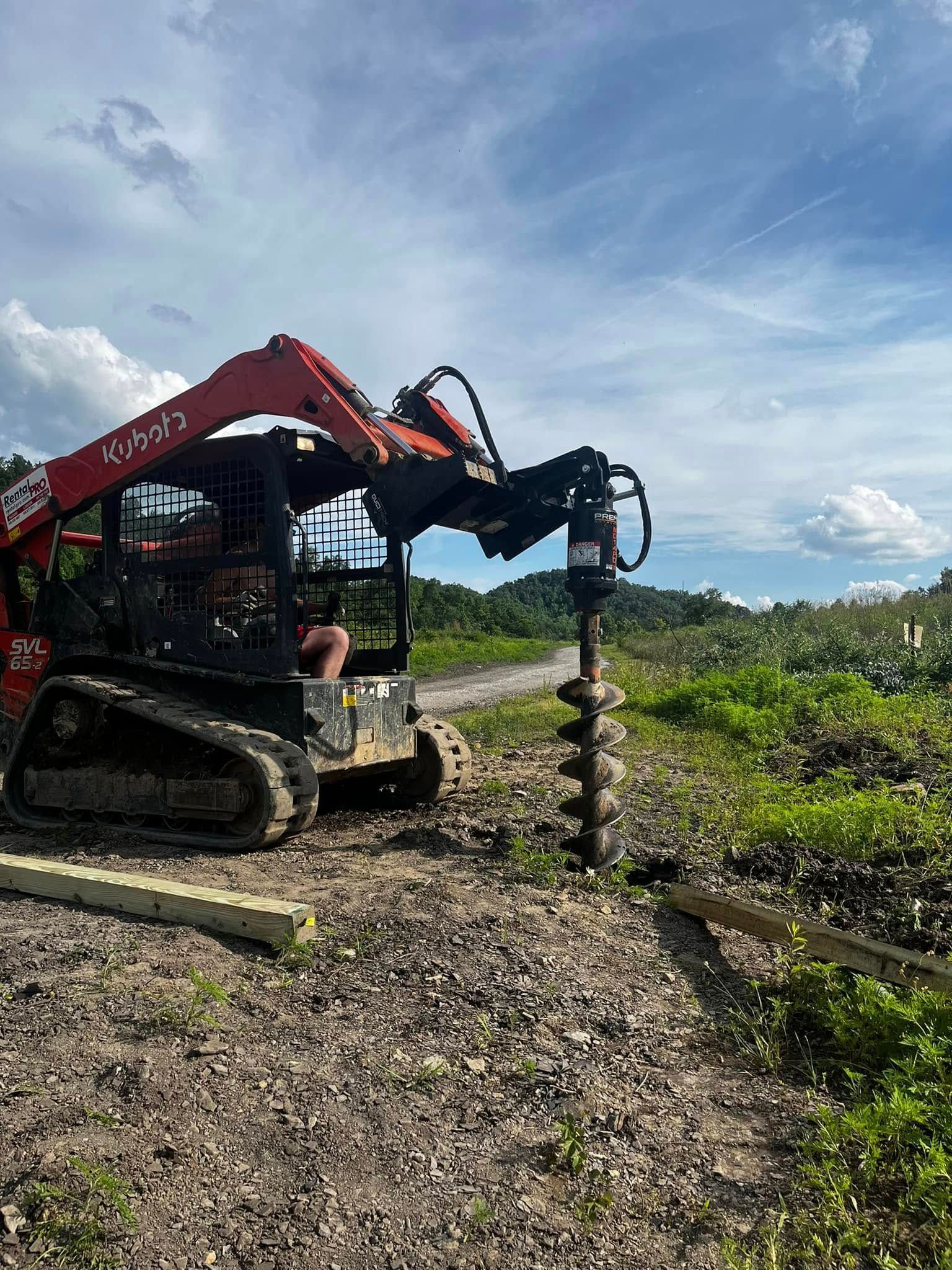 A bulldozer is drilling a hole in the ground in a field.