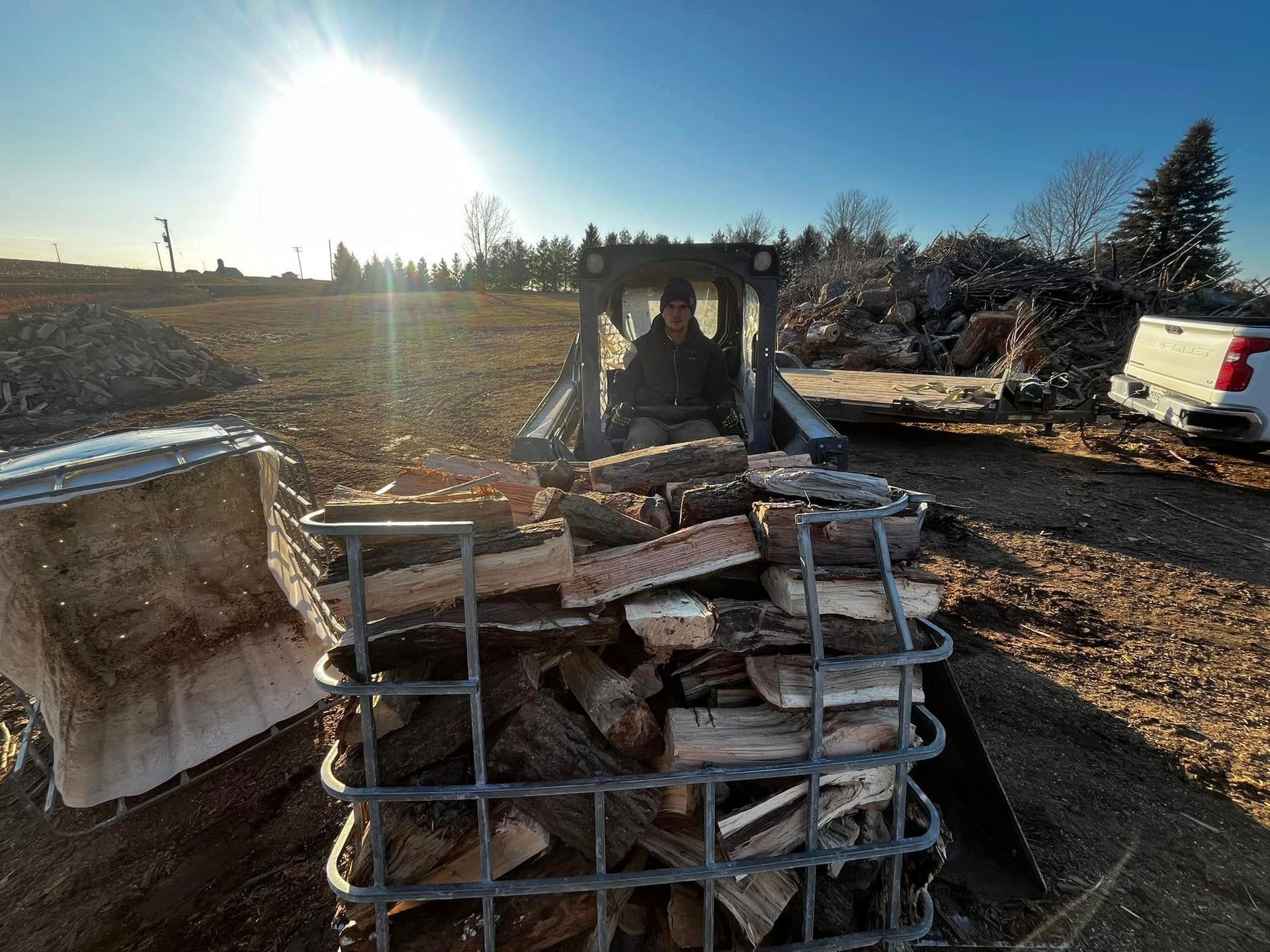 A pile of wood is sitting in front of a bulldozer.