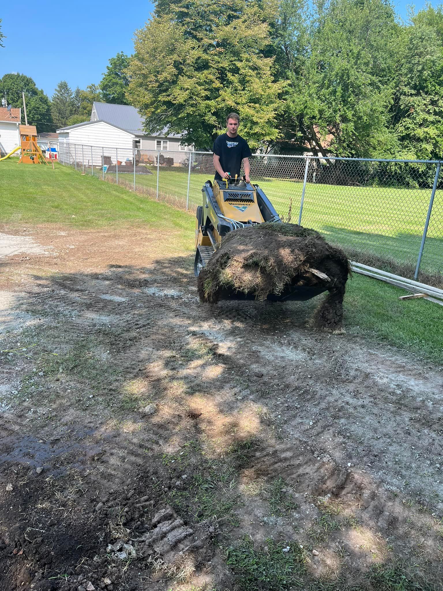 A man is driving a tractor through a muddy field.