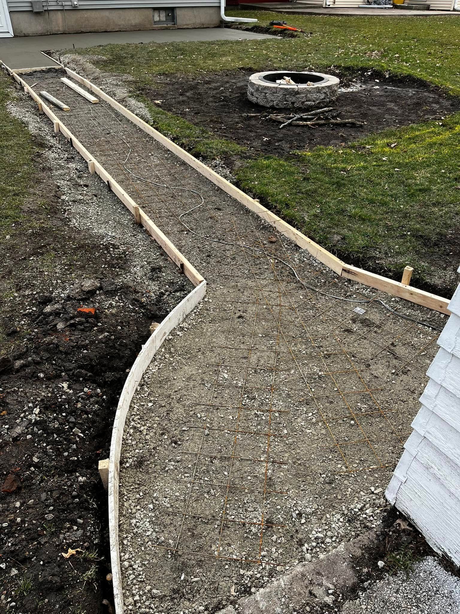 A concrete walkway is being built in front of a house.