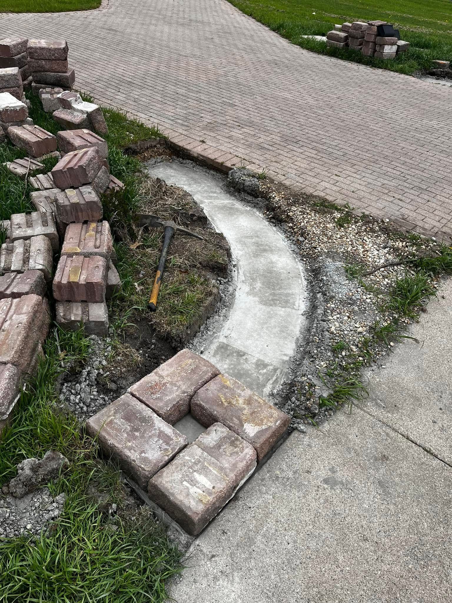 A brick walkway is being built next to a brick walkway.