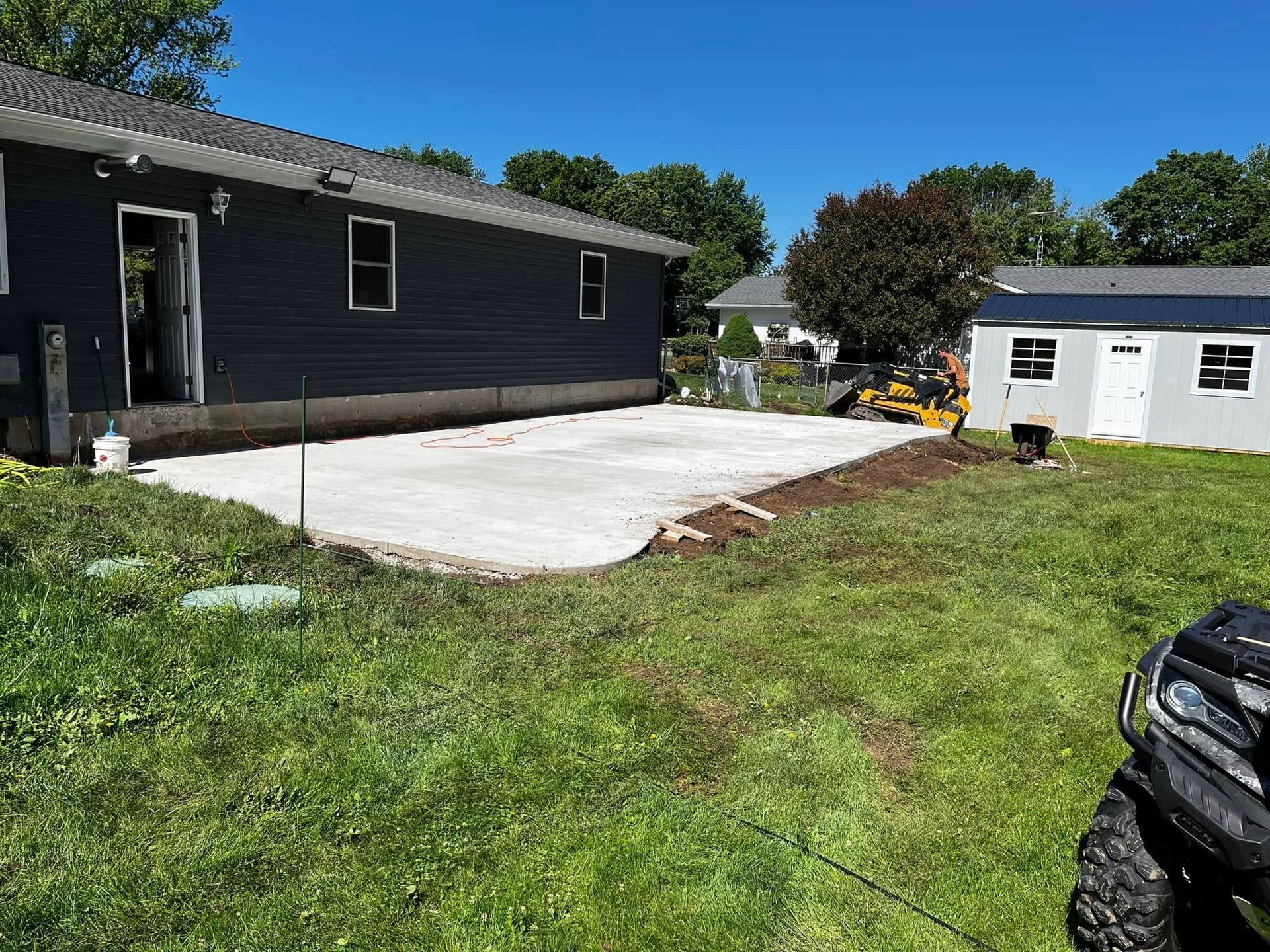 A concrete driveway is being built in front of a house.