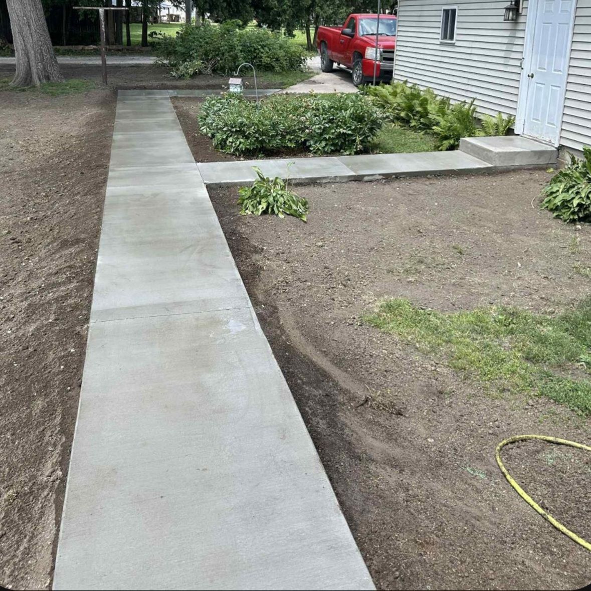 A concrete walkway is being built in front of a house.