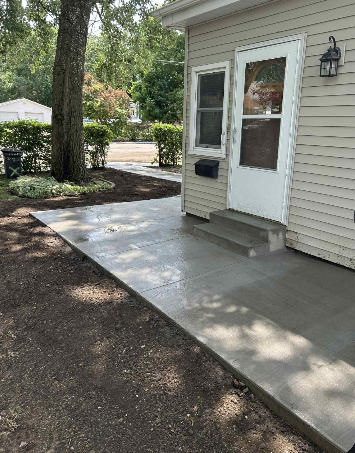A concrete walkway leading to the front door of a house.
