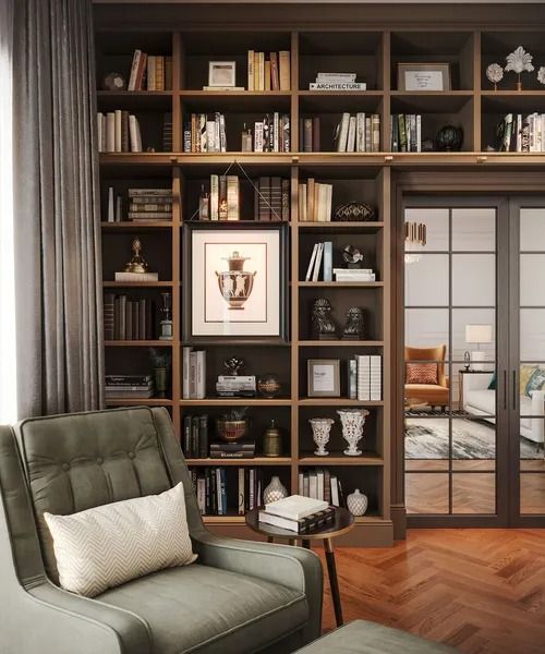 Cozy library with green armchair, large wooden bookshelves filled with books, and a doorway to another room.